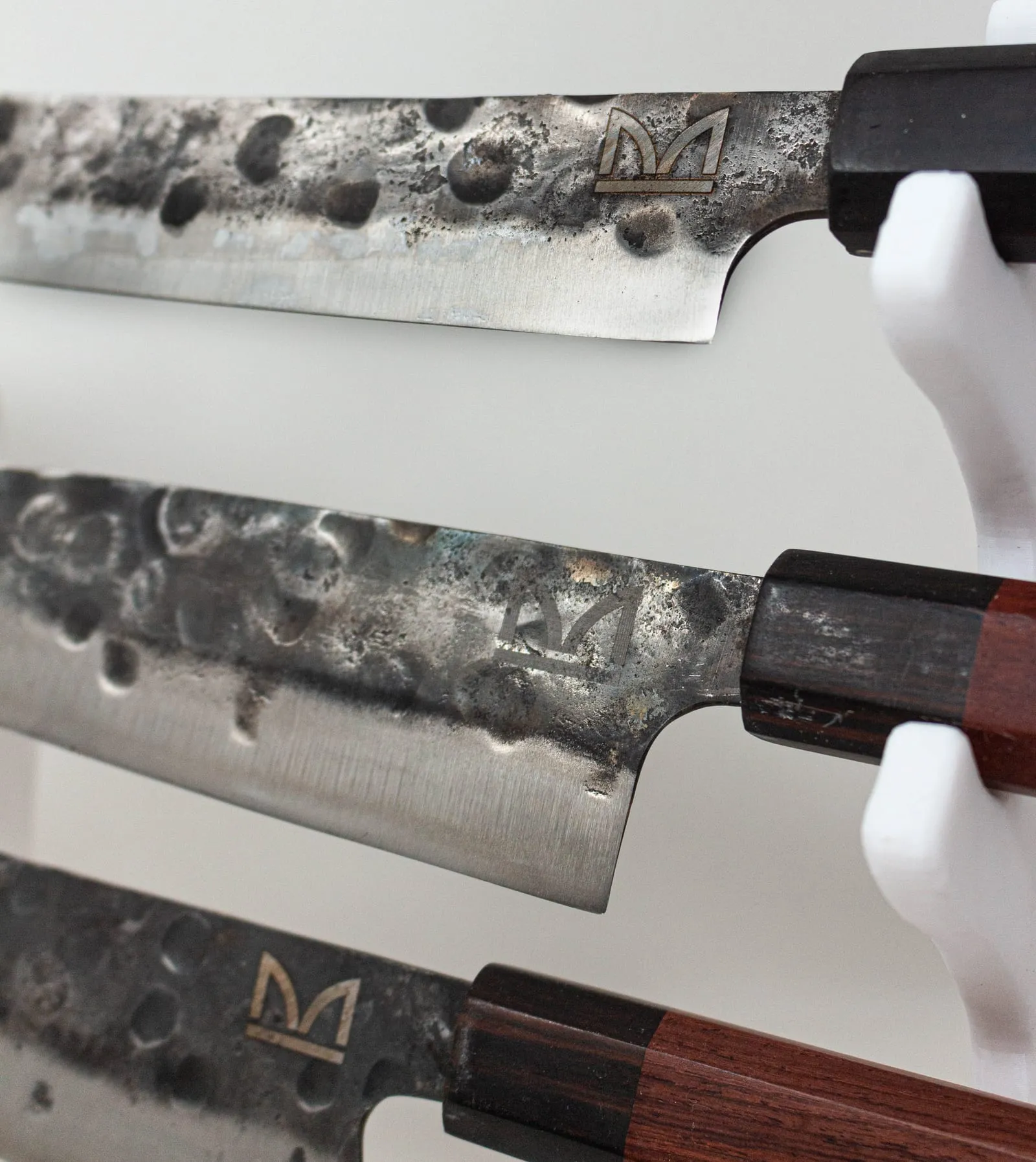Tres cuchillos de hoja texturizada con monograma grabado y mango de madera